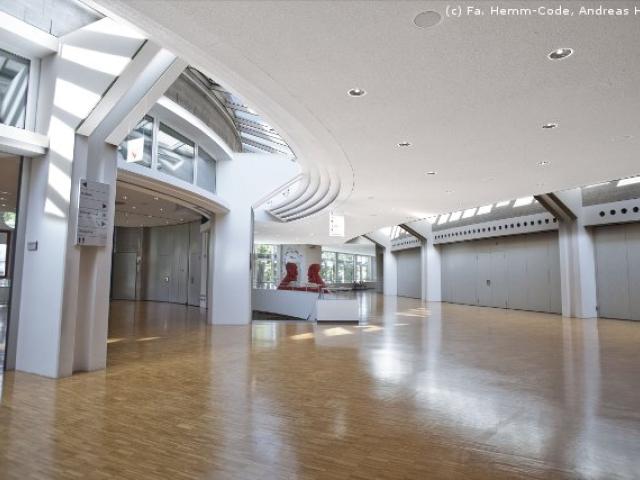 Ein leerer, geräumiger Raum mit einer gewölbten weißen Decke und Einbauleuchten.