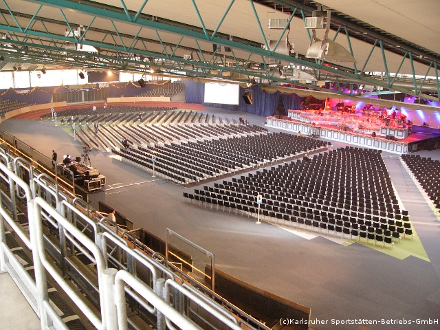 Ein großer Auditorium mit Sitzen, die in einem Halbkreis angeordnet sind.