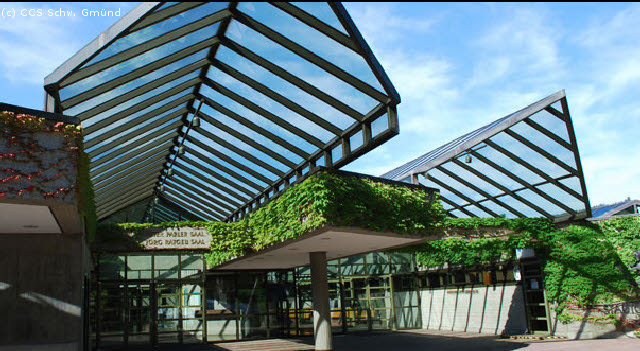 Ein umweltfreundliches Gebäude mit großen Glasfenstern und einem grünen Dach.