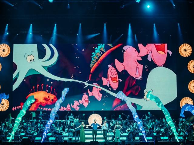 Eine Konzerthalle mit Cartoons, die auf der Wand projiziert werden.
