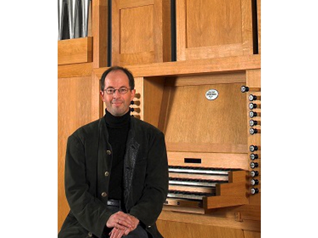 Ein Mann sitzt an der Orgel.
