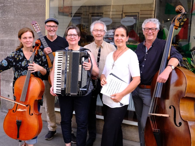 Eine Gruppe von Menschen spielt Musikinstrumente und bildet eine kleine Band